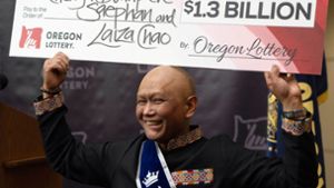 Cheng Saephan hält einen Riesencheck in Höhe von 1,3 Milliarden Dollar in die Höhe. Foto: Jenny Kane/AP/dpa