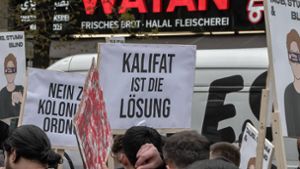 Teilnehmer einer Islamisten-Demo halten ein Plakat mit der Aufschrift „Kalifat ist die Lösung“ in die Höhe. Foto: Imago/Blaulicht-News